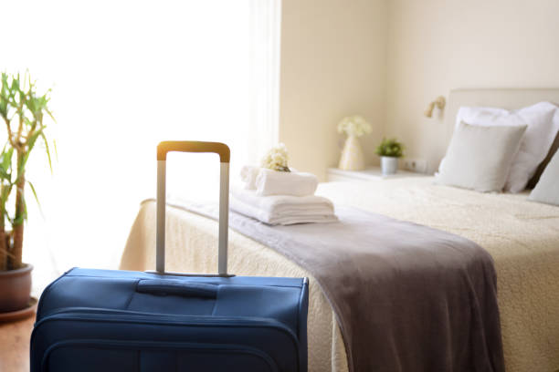istock Suitcase in very bright hotel room with clean white towels 1311257491