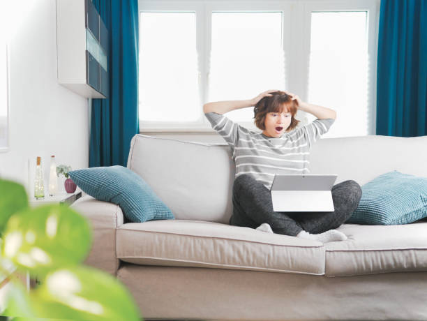 Shocked afraid worried young woman looking at laptop and holding hands on head. Home office and information overload concept. bill payment or social media messages issues. Debt for studying or rent conmocionado miedo preocupado mujer joven mirando la computadora portátil y cogido de la mano en la cabeza. concepto de oficina en el hogar y sobrecarga de información. problemas de pago de facturas o mensajes de redes sociales. deuda por estudiar o alqu