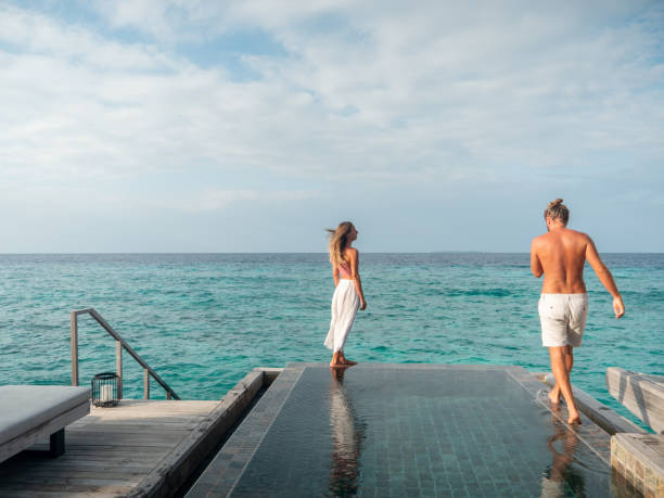 istock Couple walking at the edge of infinity pool 1311258056
