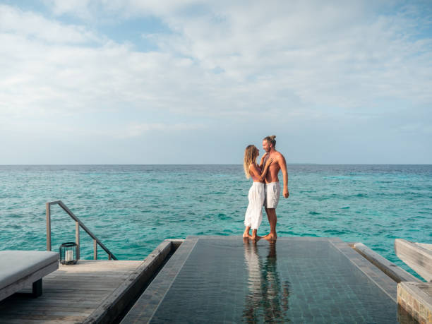 istock Couple walking at the edge of infinity pool 1311258613