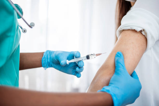 istock Hands with protective gloves fills syringe with vaccine 1311259031