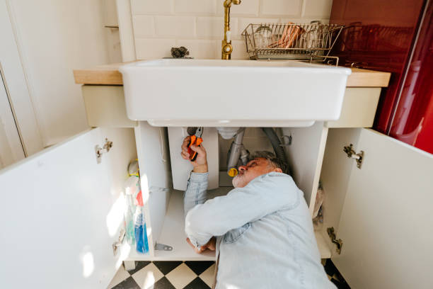 uomo maturo che risolve problemi idraulici in cucina - lavandino rotto foto e immagini stock