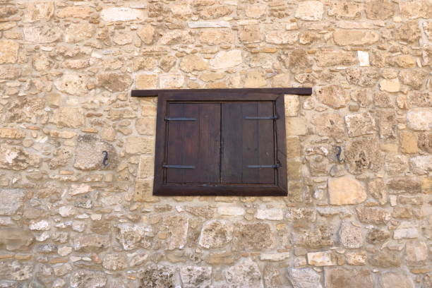 istock Background of decorate sand stone wall surface with wooden window 1311261552
