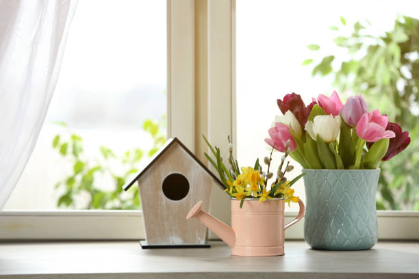 istock Beautiful spring flowers with birdhouse on window sill 1311261566