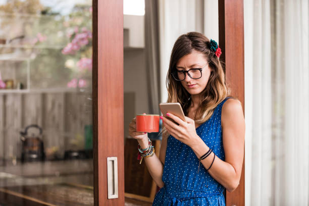 istock Young adult woman using smartphone in a modern home. 1311261603