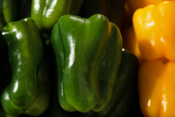 Stack of green and yellow capsicum.