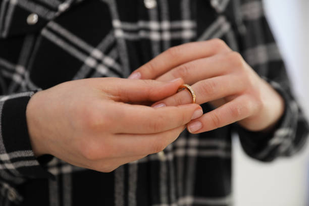istock Woman taking off wedding ring on grey background, closeup. Divorce concept 1311261708