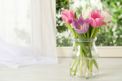 A fresh bouquet of lilacs set on a cozy, rustic porch.