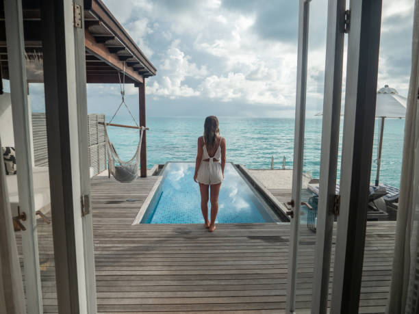 istock Woman contemplates luxury villa over water 1311265016