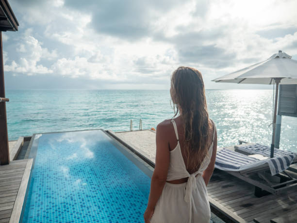 istock Woman contemplates luxury villa over water 1311265090