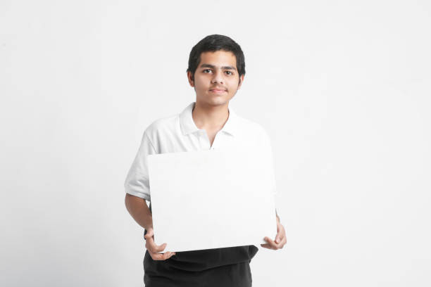 istock Young indian college student showing white board on white background 1311265151