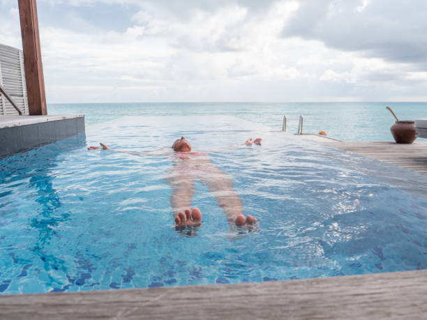 istock Woman floats on the surface on an infinity pool 1311265337