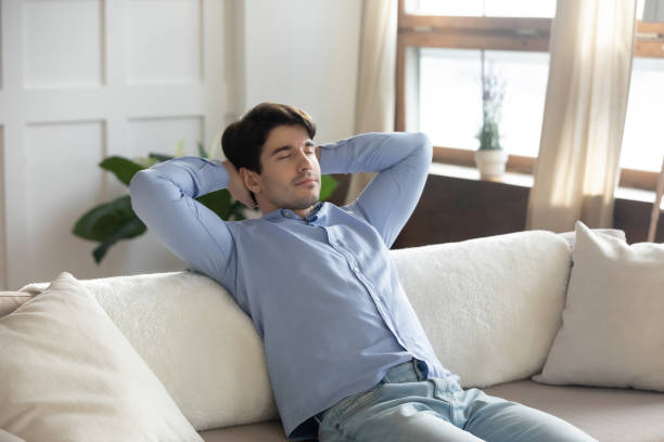 istock Close up peaceful man relaxing with closed eyes on couch 1311267052