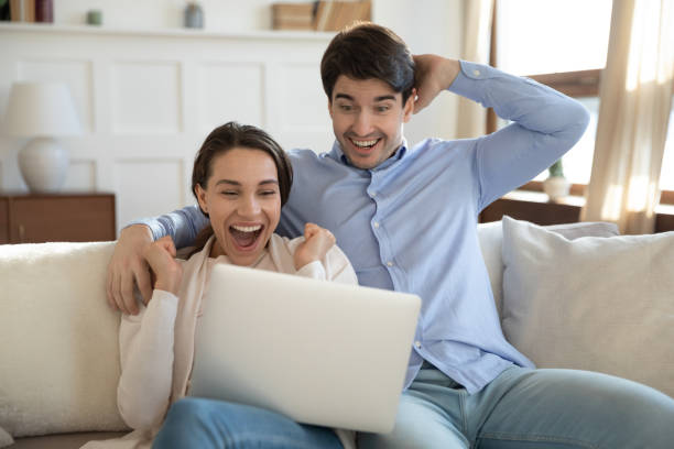 istock Close up overjoyed couple looking at laptop screen, celebrating win 1311267368