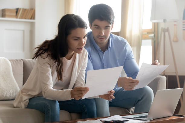 istock Close up serious young couple reading documents, calculating finances 1311267388