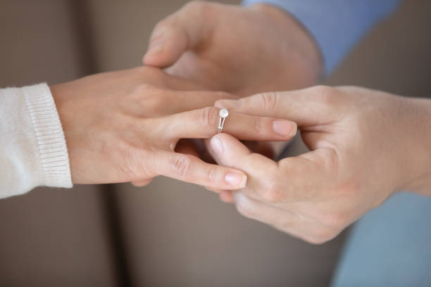 istock Close up man putting wedding ring on woman finger 1311267402