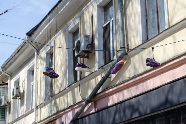 culture treet. chaussures sur des fils. vieilles baskets suspendues à un câble. - treet photos et images de collection