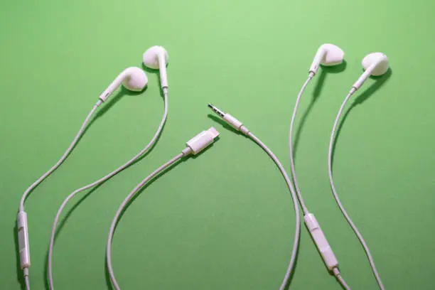 Photo of headphones mini jack versus lightning connector adapter isolated chromakey