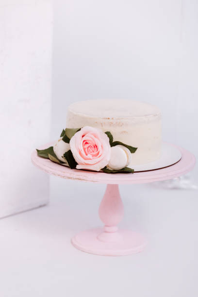 istock Beautiful white cream cake decorated with 2 year old candle and roses in white studio. Birthday party - Concept of a year of birth, party, celebration of life and memorable moments. 1311273717
