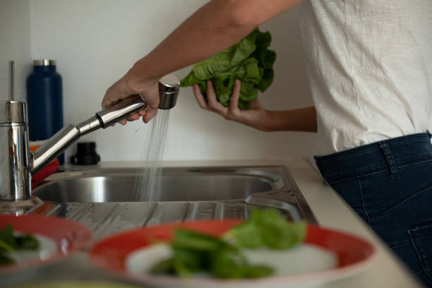istock Woman washes lettuce for healthy salad 1311273841