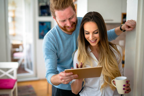 istock Happy couple using tablet and drinking coffee at home 1311273875