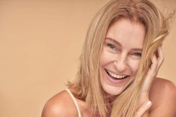 istock Happy pretty mature woman posing while touching hair by hands 1311274068