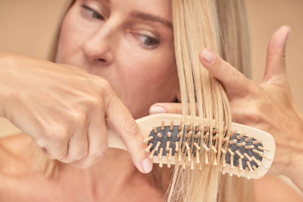 istock Mature blonde woman combing her hair, selective focus 1311274678