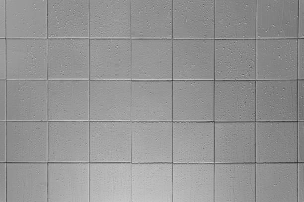istock The texture of light gray square glossy ceramic tiles with water drops. Soft lighting. 1311275799