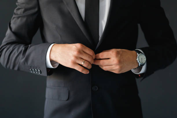 istock The groom fastens the button of his black jacket 1311276001