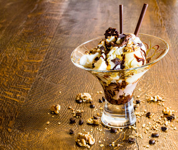 istock Ice cream cup with ice cream, cream, nuts and chocolate shards as a decoration idea for restaurant and cafe. Copy space 1311276662
