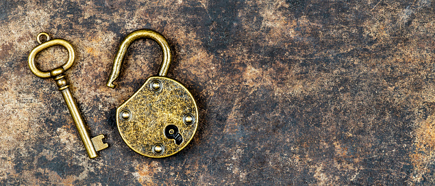 Photograph of a padlock made of brass and steel, white background, isolated.