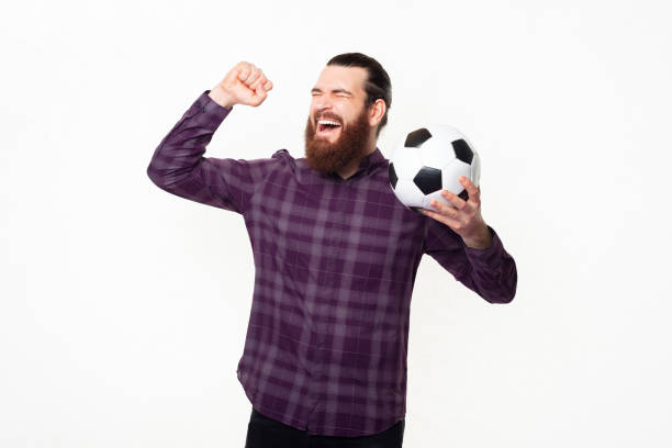 istock Amazed cheerful man in checkered shirt celebrating and supporting favorite team 1311279392