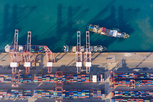 Aerial view sea port warehouse and container ship or crane ship working for delivery containers shipment. Suitable use for transport or import export to global logistics, Container ship in import export and business logistic, Container ship loading and unloading in deep sea port.