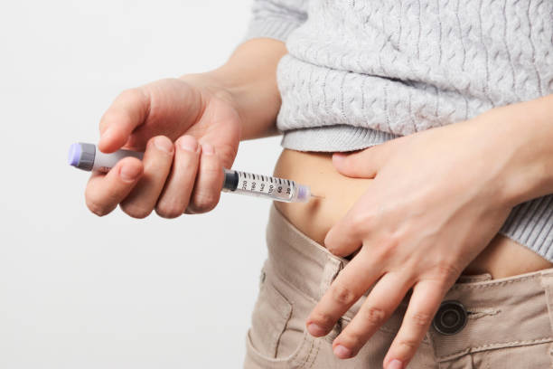 istock Young woman doing insulin injection pen, close-up. 1311280636