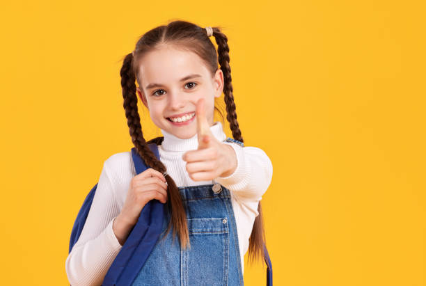 smiling girl with backpack pointing at camera - 16710 imagens e fotografias de stock