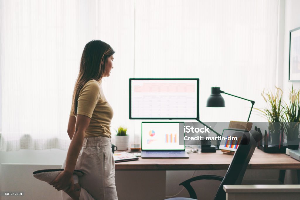 COVID-19 Home office midday break Woman stretching while working at home during pandemic lockdown Exercising Stock Photo