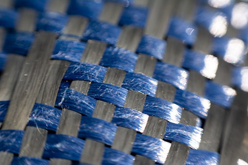 A macro image of a blue braided fabric as a texture or background.