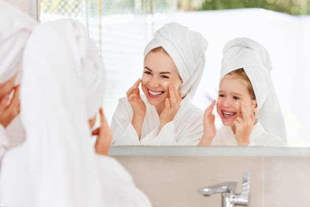 liebende mutter und tochter während der spa-hautpflege - mirror mother bathroom daughter stock-fotos und bilder