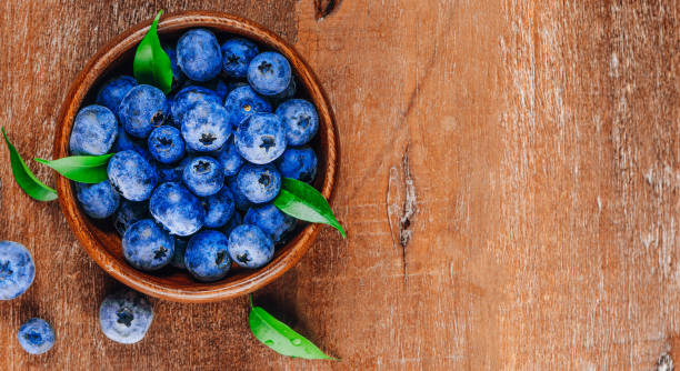 istock Blueberries in a bowl on a wooden background top view free space for text 1311287593