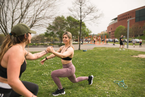 istock Two young women exercising together in a park 1311287763