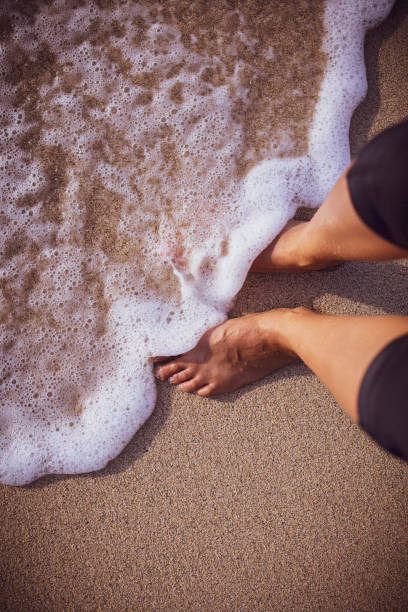 persona de pie en el agua en una playa en hawai'i - oahu water sand beach fotografías e imágenes de stock