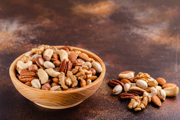istock Various Nuts in wooden bowl on dark background 1311291941