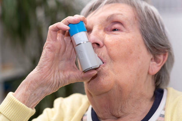 istock Old woman using an asthma inhaler 1311292059
