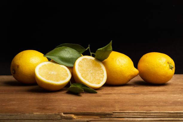 istock Lemons on a wooden table and on a black background 1311295101