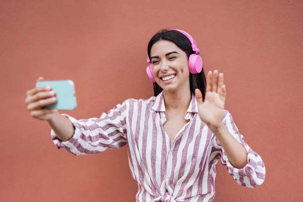 istock Happy latin woman waving hands while using smartphone for video call 1311295200