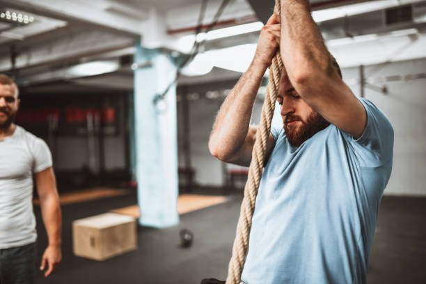 istock Focused Male Tries New Rope Climbing Techniques With Instructor's Help 1311296358