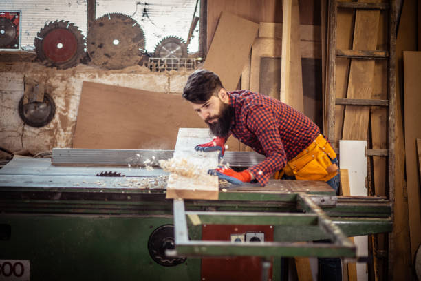 istock Young man at carpentry cutting wood with a circular saw 1311296608