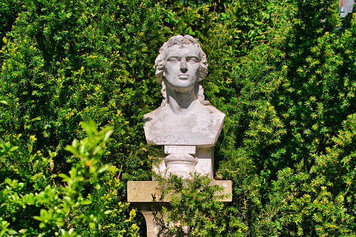 Looking at a bust of Friedrich Schiller at his garden house in Jena. Friedrich Schiller  lived here with his family from 1797 to 1799. Some of his most important works, such as parts of Wallenstein and Maria Stuart, as well as numerous ballads, were created here. Today the house is owned by the Friedrich Schiller University, which maintains a museum and a discourse space with numerous types of events.