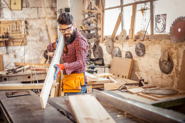 istock Young man at carpentry checking curvature of a plank 1311297008