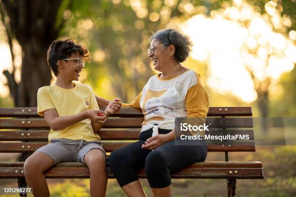 Grandmother And Grandson Sitting On The Bench In The Square Stock Photo - Download Image Now